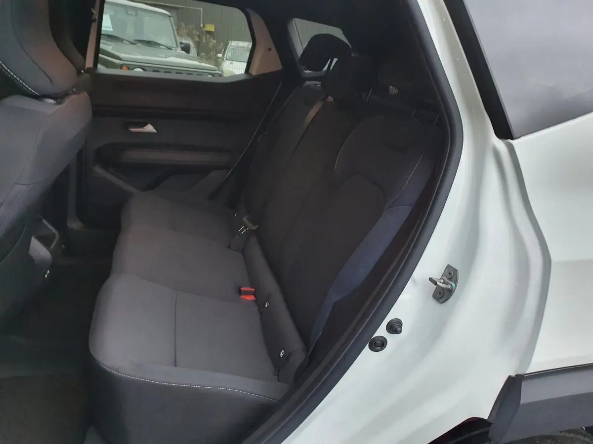 Vue côté droit de la banquette arrière noire du Dacia Duster blanc glacier avec ceinture 3 points et appuie-têtes visibles.