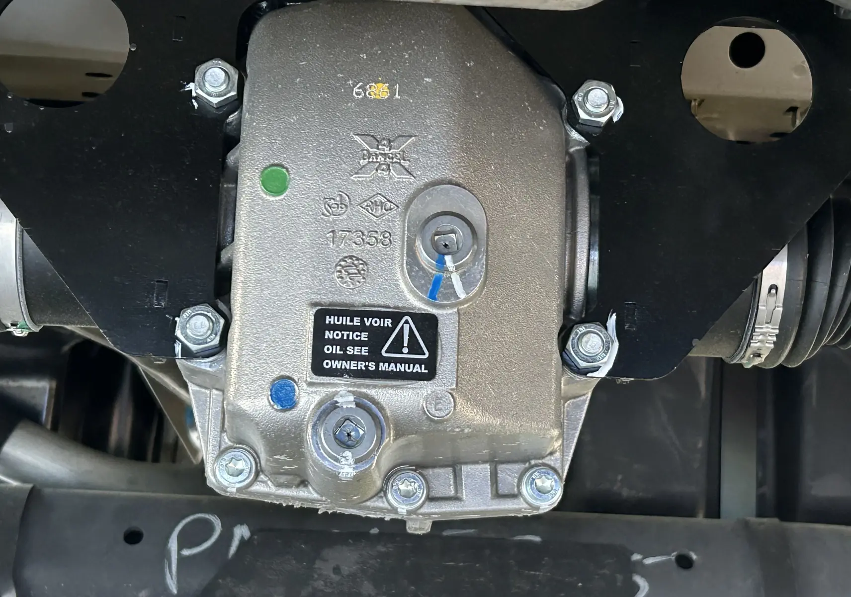 Gros plan sur le boîtier mécanique du pack 4x4 Dangel du Peugeot Partner gris Artense, montrant les fixations et indications d'huile.