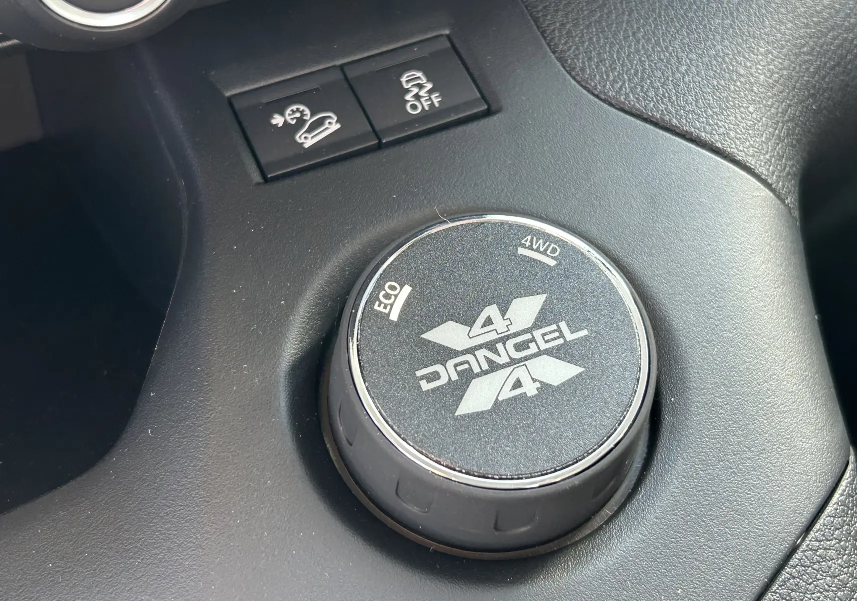 Gros plan sur le sélecteur rotatif Dangel 4x4 dans l'habitacle noir du Peugeot Partner gris Artense.