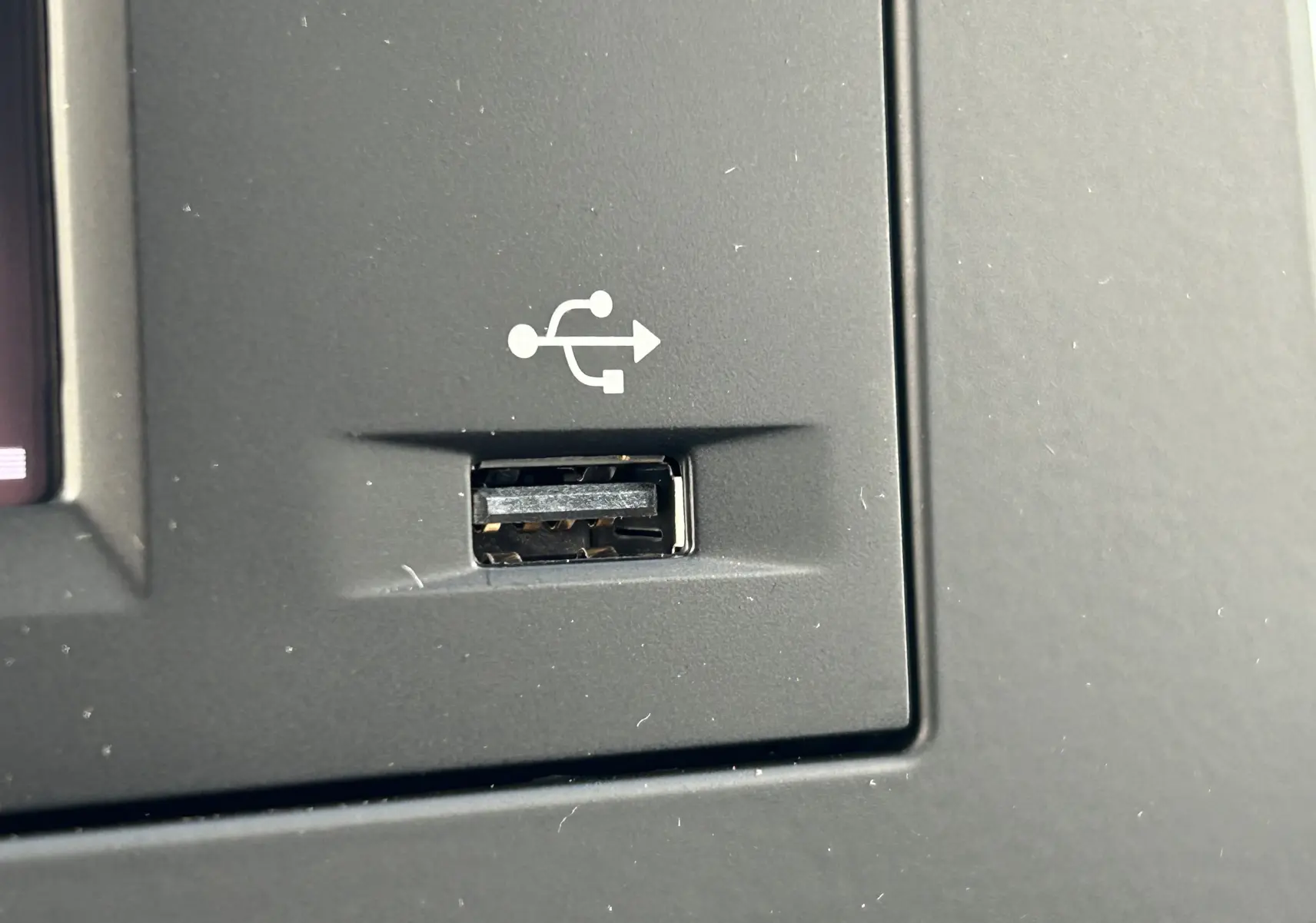 Gros plan sur un port USB intégré au tableau de bord gris du DANGEL Peugeot Partner 4x4 L1 2025.