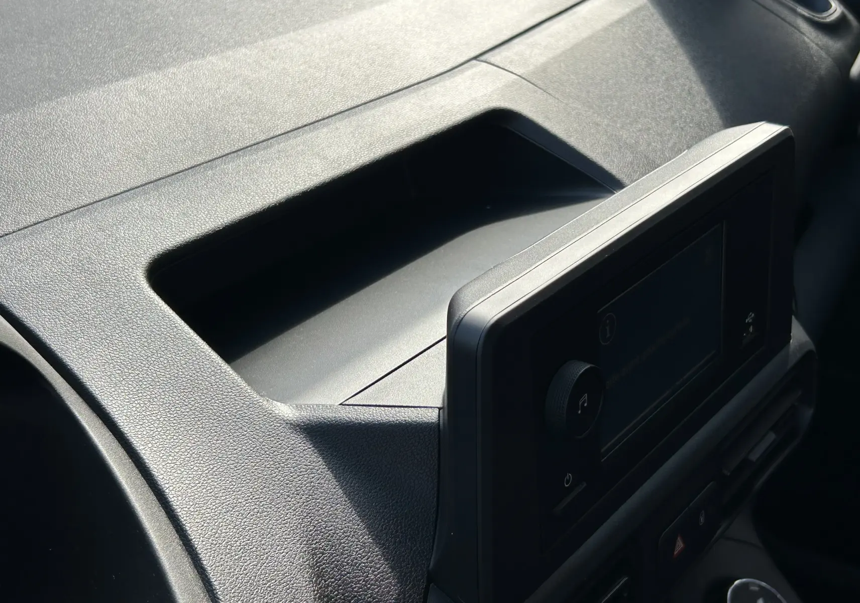 Vue rapprochée de la console centrale noire avec écran tactile du Peugeot Partner Dangel gris Artense 2025.