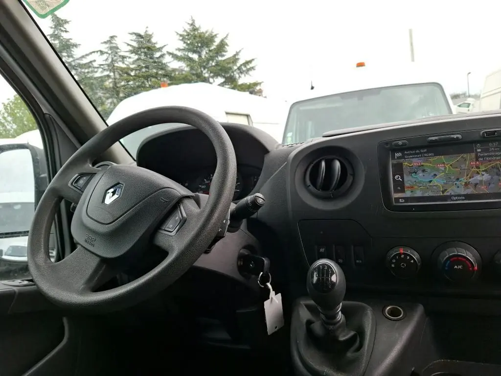 Vue intérieure côté conducteur du Renault Master blanc 2019, montrant le volant, levier de vitesse manuel et écran GPS intégré.