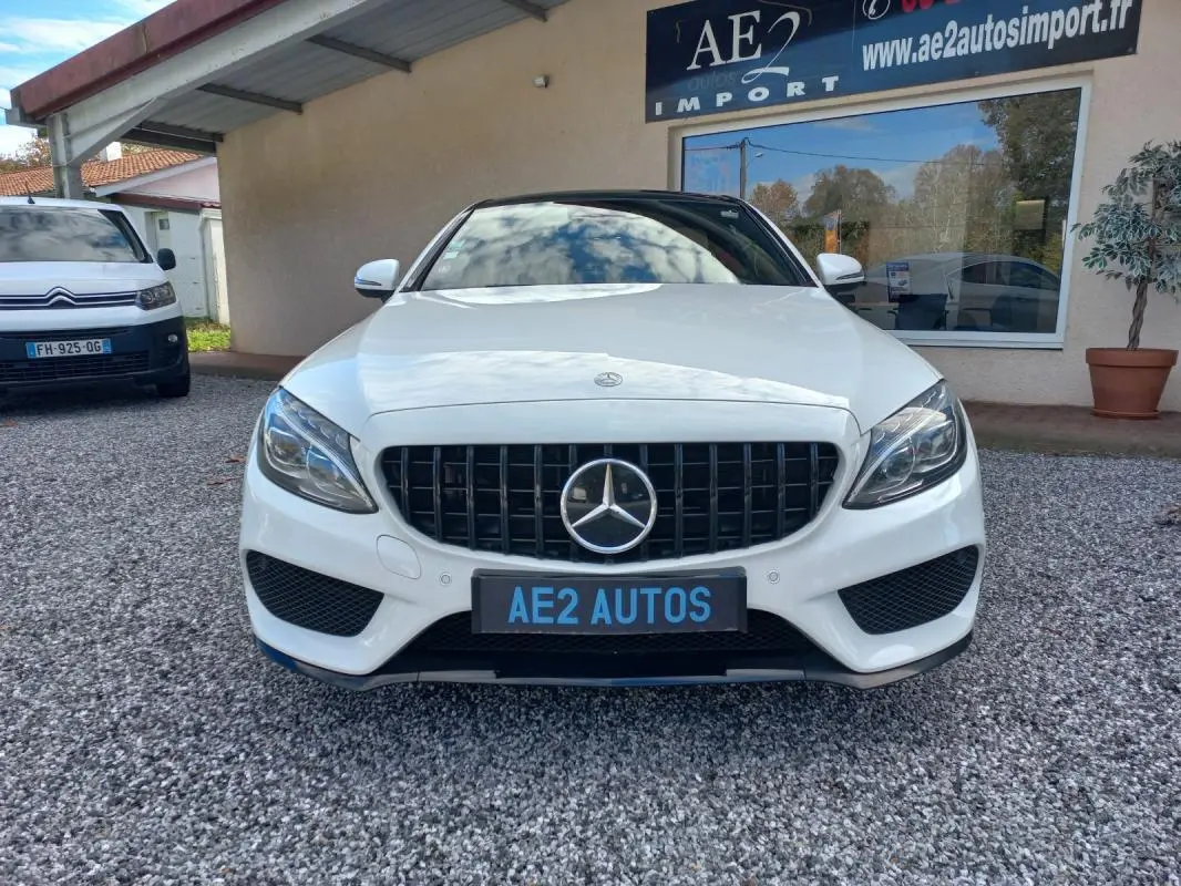 Vue de face d'une Mercedes Classe C Coupé blanc brillant avec calandre noire et logo étoile central.