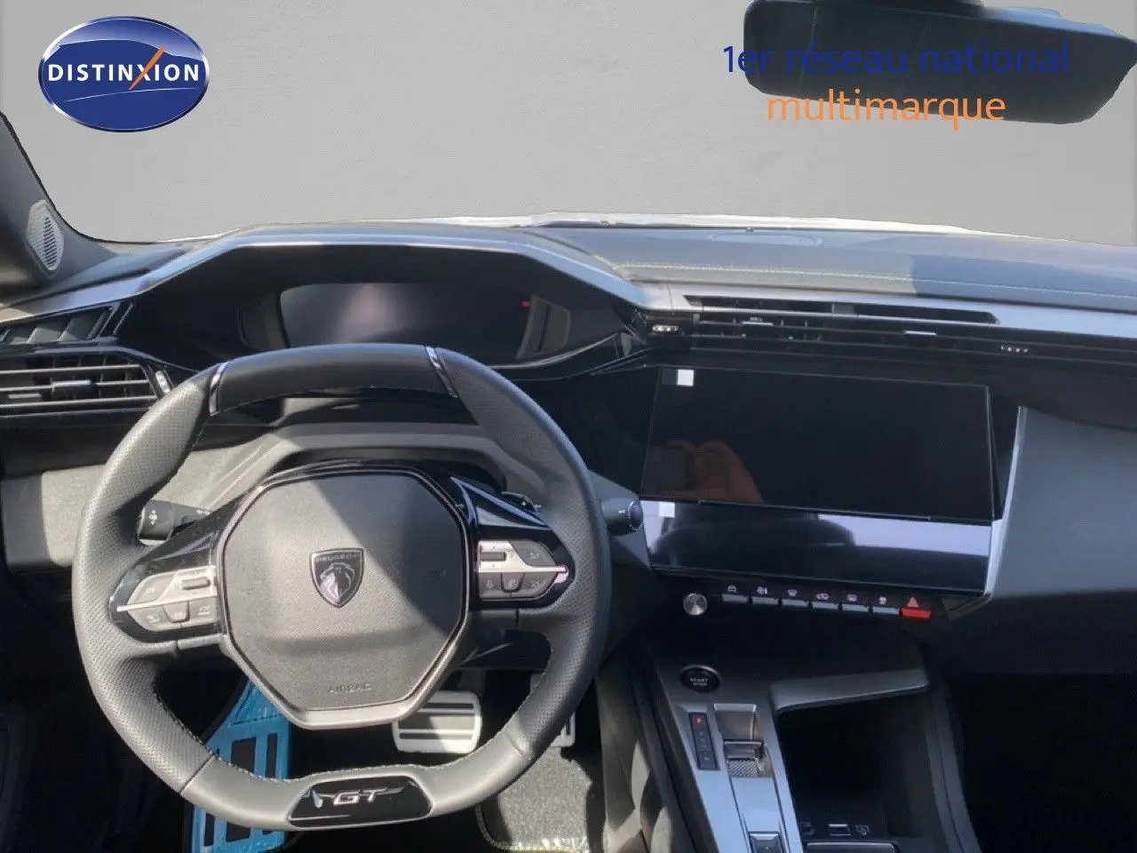 Vue intérieure centrée sur le volant GT et la console digitale d'une Peugeot 308 Hybrid blanche, finition 2026.