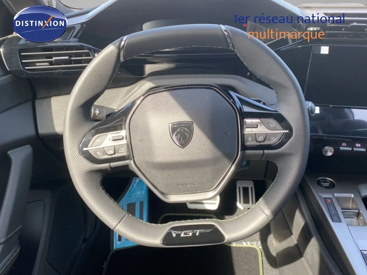 Volant multifonction GT en cuir perforé avec logo Peugeot, vue rapprochée de l'habitacle intérieur noir du Peugeot 308 Hybrid 2026.