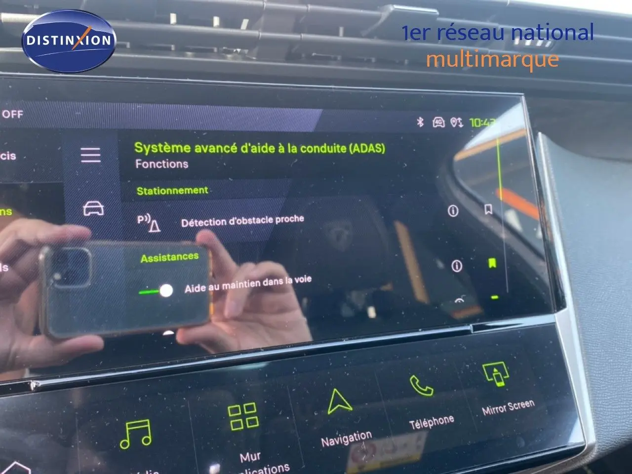Gros plan sur l'écran tactile intérieur du Peugeot 308 Hybrid blanc, affichant les aides à la conduite avancées.