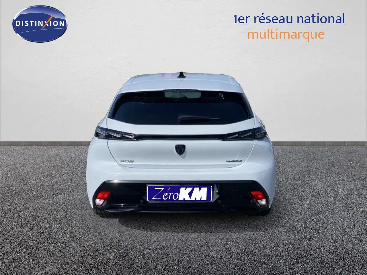 Vue arrière d'une Peugeot 308 Hybrid blanche Okenite Metal avec feux effilés et logo noir sur fond clair.