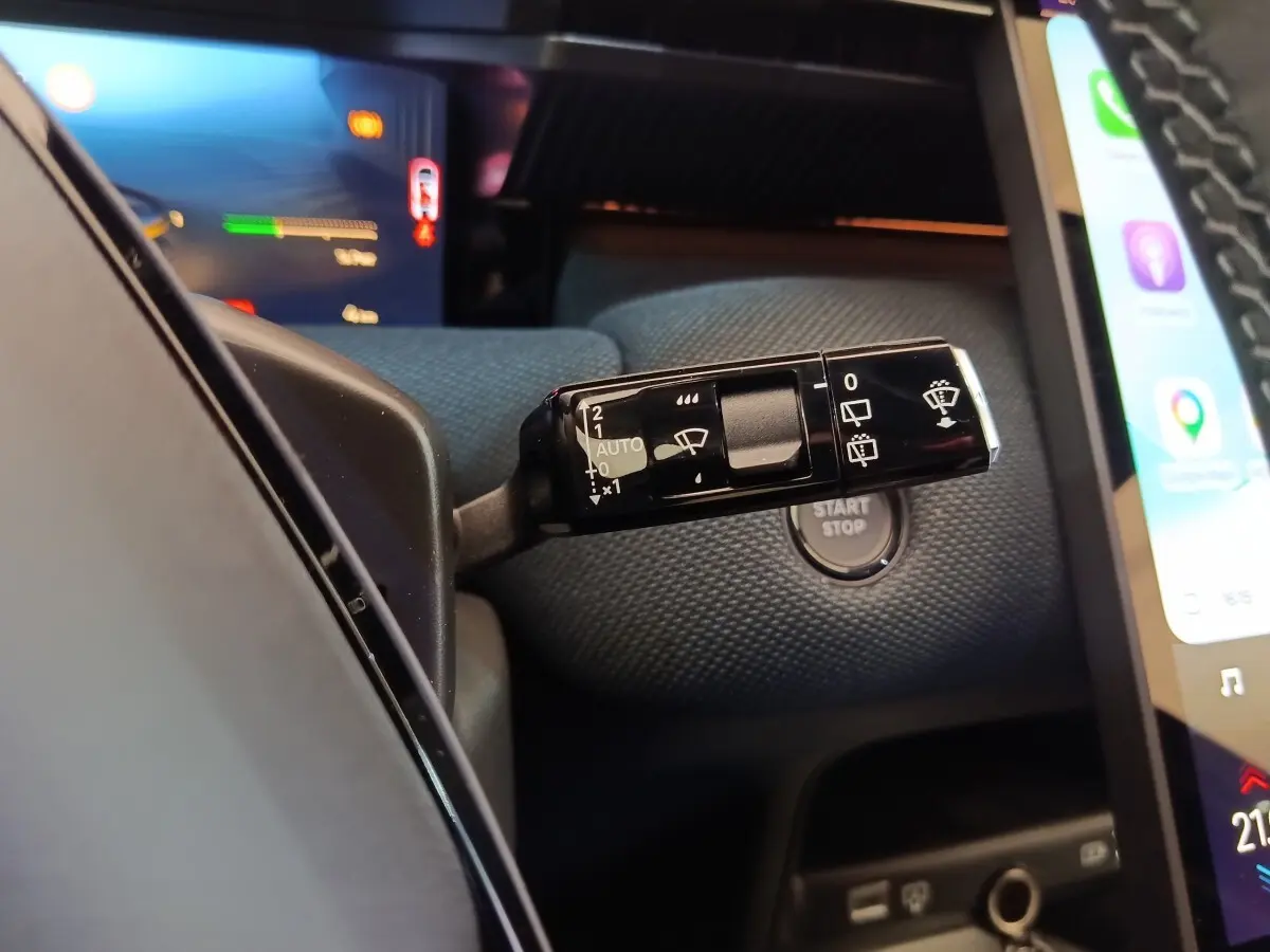 Gros plan sur la commande d’essuie-glace noire et le bouton start/stop dans l’habitacle du Citroën C5 Hybride 2026.