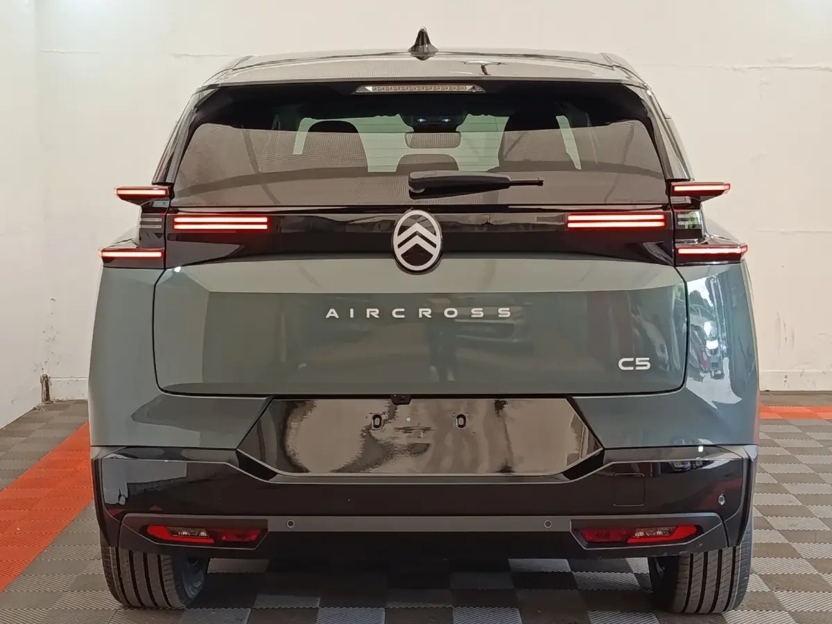 Vue arrière d'un Citroën C5 Aircross hybride vert avec feux LED horizontaux distinctifs et toit noir.