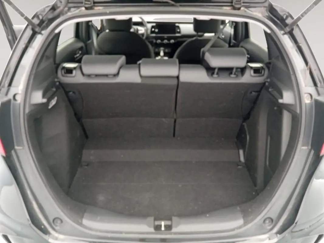 Vue arrière du coffre ouvert de la Honda Jazz 2024 noire, montrant l'espace de chargement et les sièges arrière rabattus.