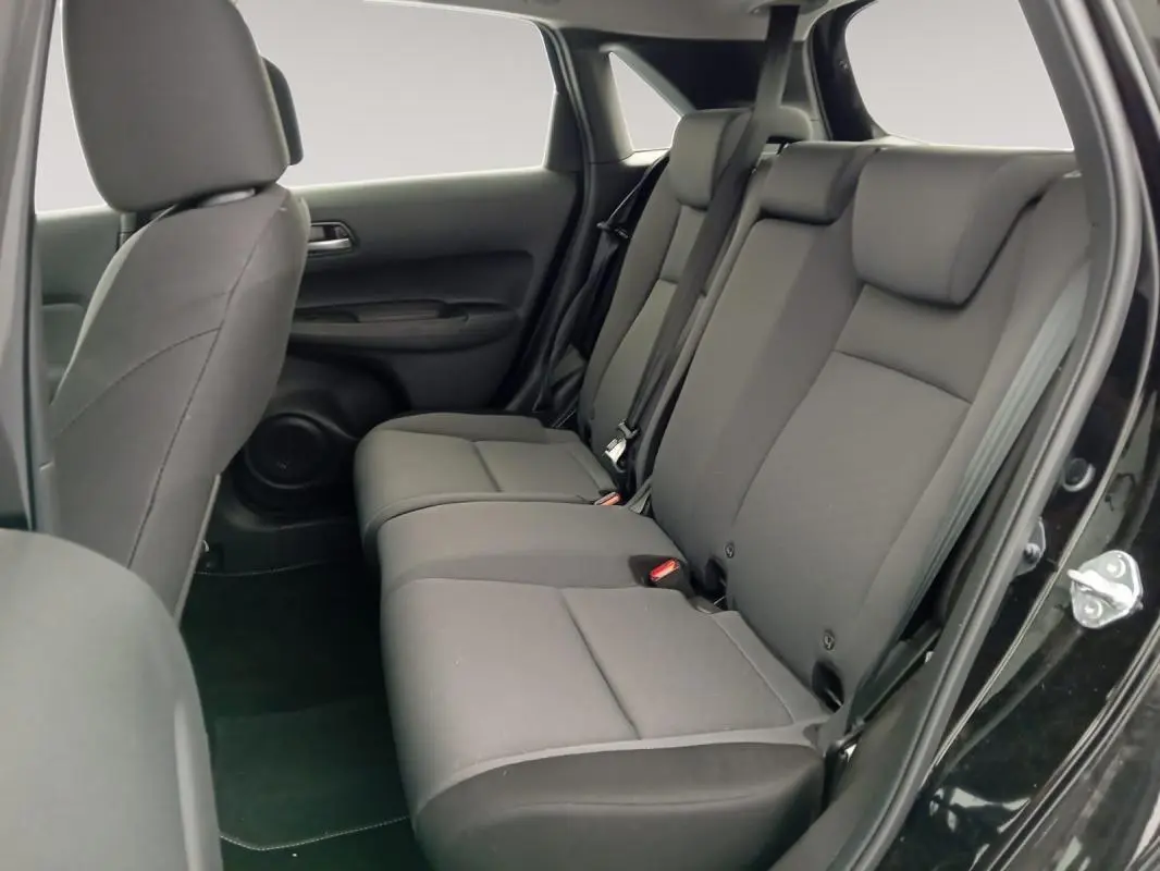 Vue intérieure côté droit des sièges arrière noirs de la Honda Jazz E:HEV 1.5 i-MMD Advance 2024 avec porte ouverte.