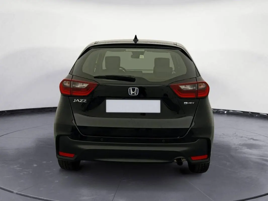 Vue arrière d'une Honda Jazz noire 2024 E:HEV 1.5 i-MMD Advance avec feux arrière rouges et logo distinctif.