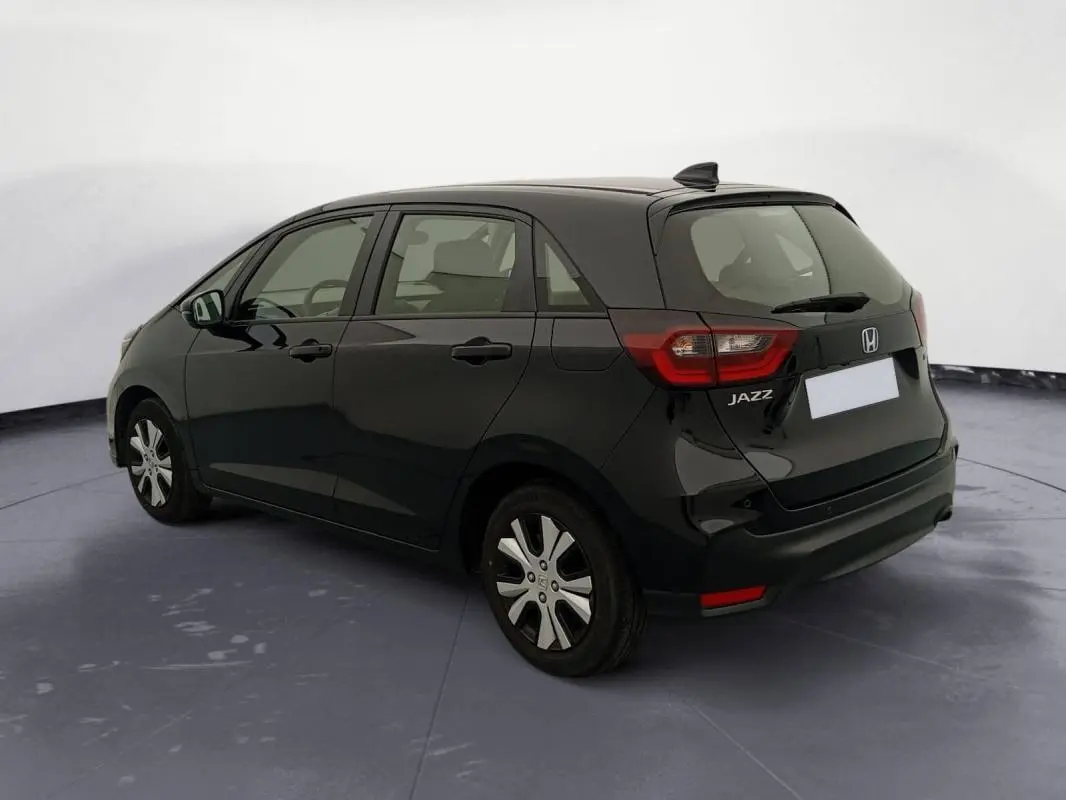 Vue 3/4 arrière droite de la Honda Jazz 2024 noire, version hybride essence E:HEV 1.5 i-MMD Advance avec jantes spécifiques.