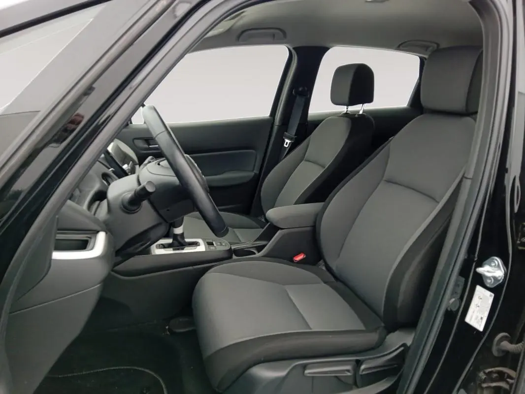 Vue intérieure côté conducteur de la Honda Jazz 2024 noire, montrant les sièges avant et le volant.