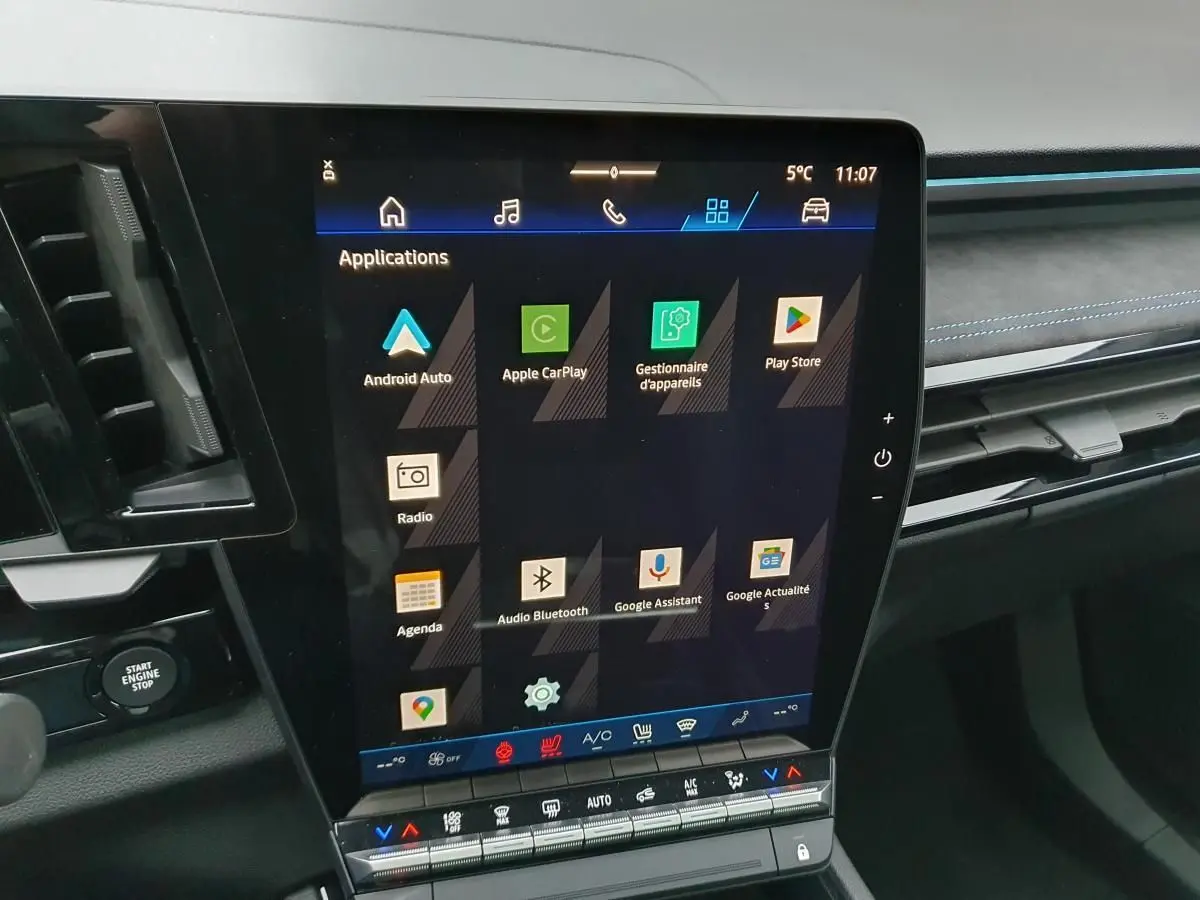 Vue intérieure centrée sur l’écran tactile vertical du tableau de bord du Renault Austral gris schiste avec finitions Alcantara.