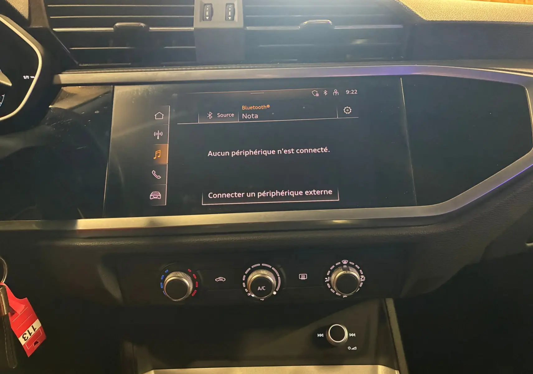 Vue rapprochée de l’écran tactile central et des commandes de climatisation du tableau de bord de l’Audi Q3 Sportback gris.