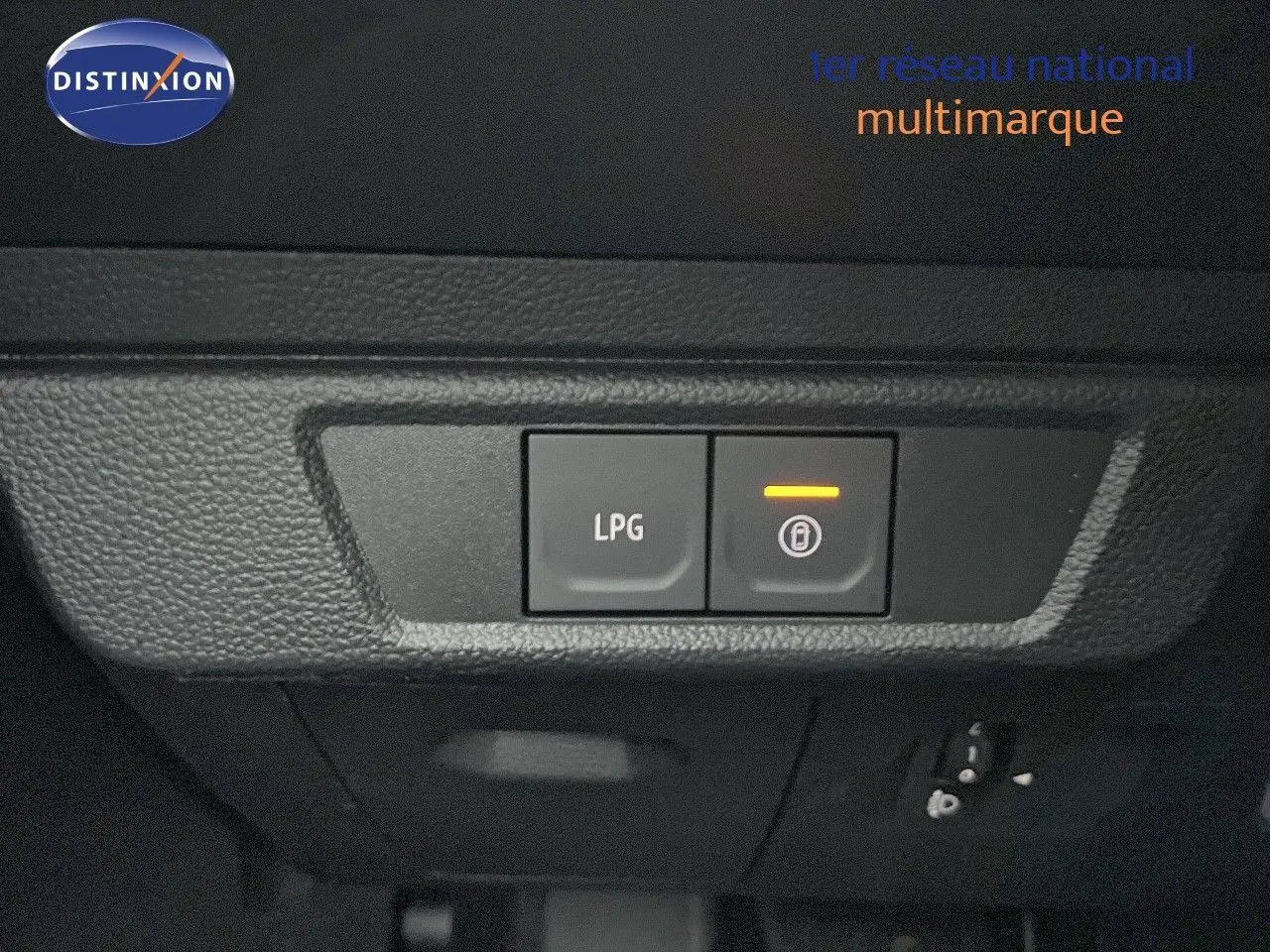 Gros plan sur les boutons de commande LPG et verrouillage intérieur du tableau de bord noir du Dacia Jogger gris schiste.