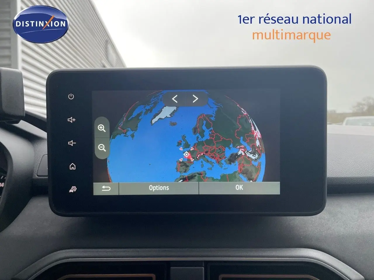 Vue intérieure centrée sur l'écran tactile du GPS affichant une carte du globe dans un Dacia Jogger gris schiste métal.