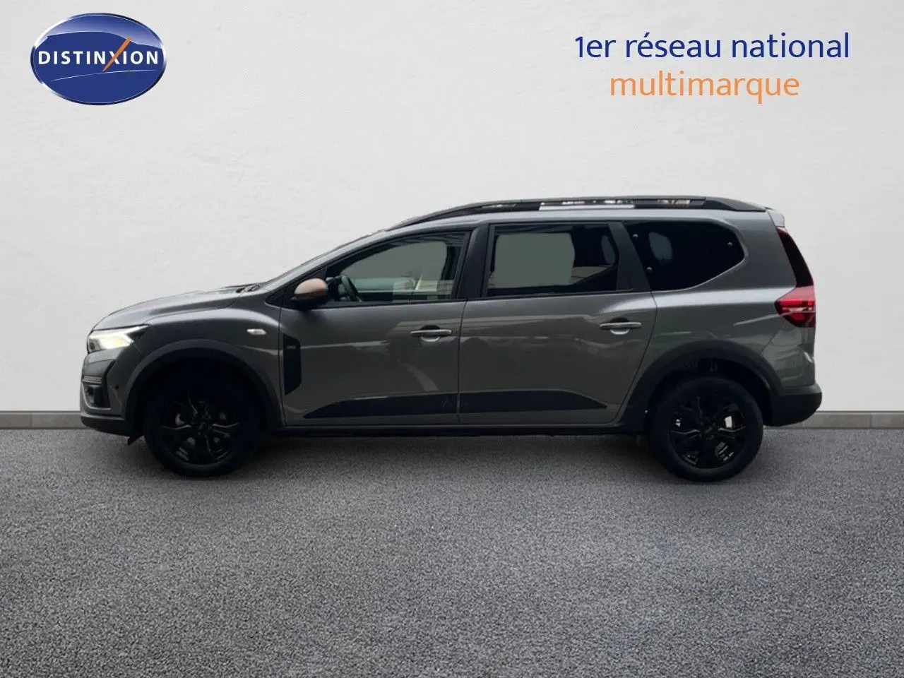 Vue latérale droite d'un Dacia Jogger gris schiste métal avec jantes noires et rétroviseurs couleur bronze.
