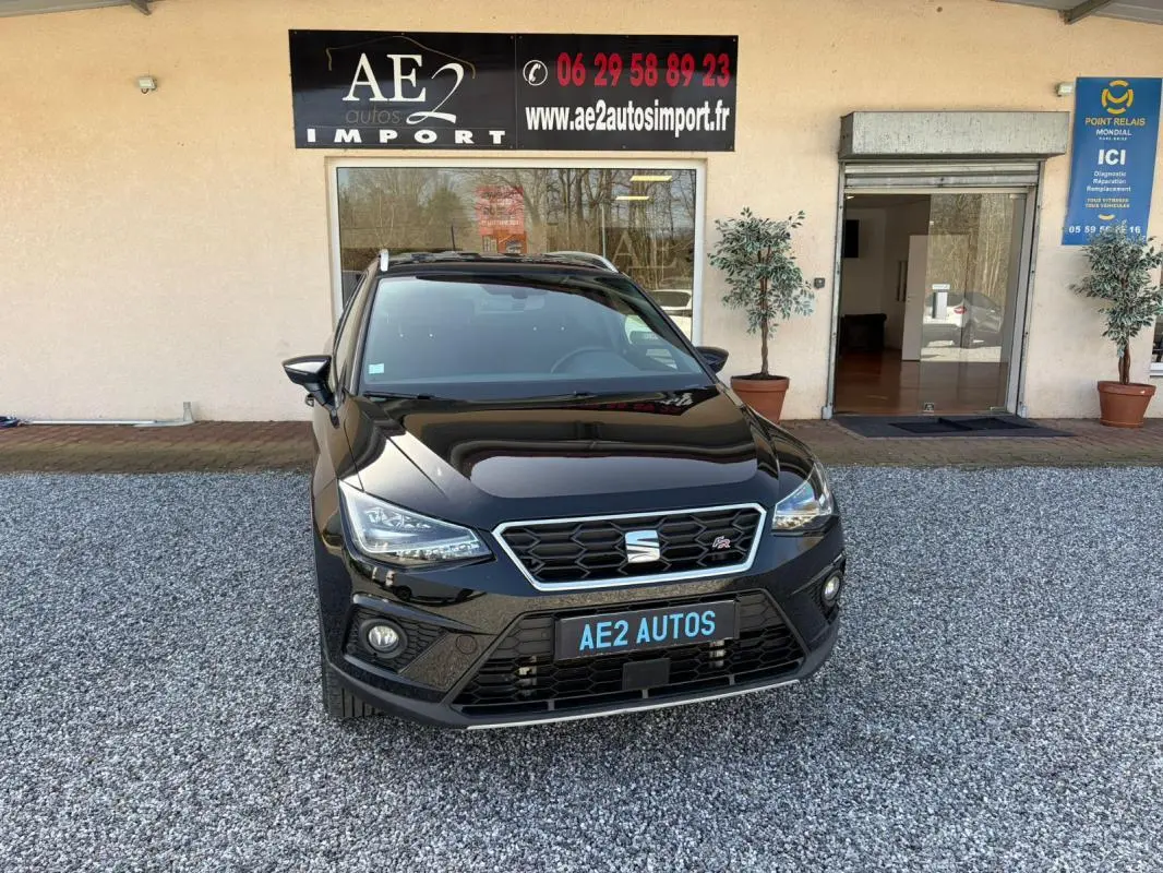 SEAT Arona noir vue de face, mettant en valeur la calandre hexagonale et les phares LED distinctifs.
