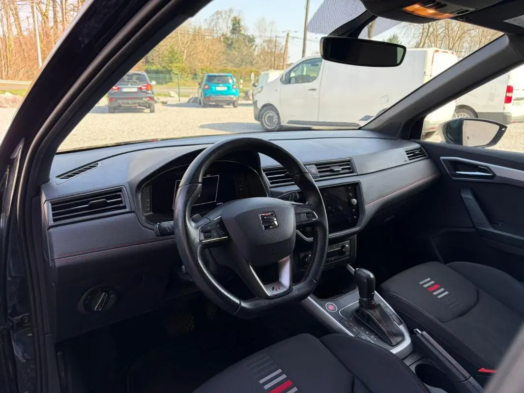 Vue intérieure côté conducteur du SEAT Arona noir 2020, avec volant multifonction et console centrale de boîte automatique.