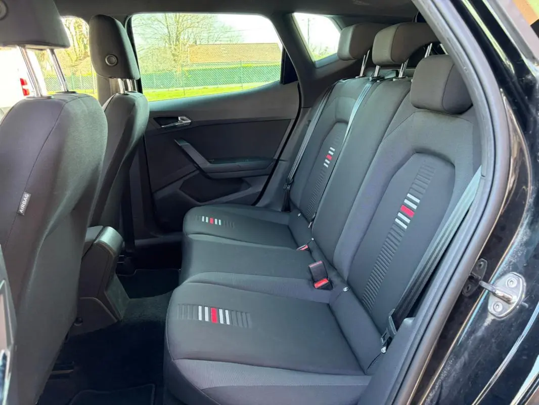 Vue intérieure côté droit des sièges arrière noirs du SEAT Arona 2020 avec motifs gris et rouges sur les assises.