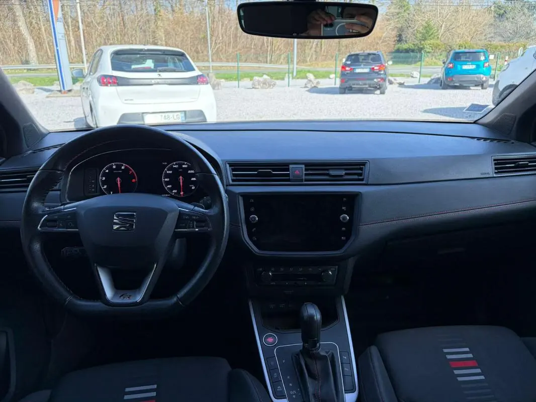 Vue intérieure frontale du tableau de bord et volant noir du SEAT Arona 2020, version FR avec détails rouges sur les sièges.