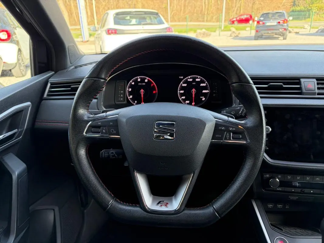 Vue intérieure centrée sur le volant noir du SEAT Arona 2020, avec logo FR et tableau de bord numérique visible.