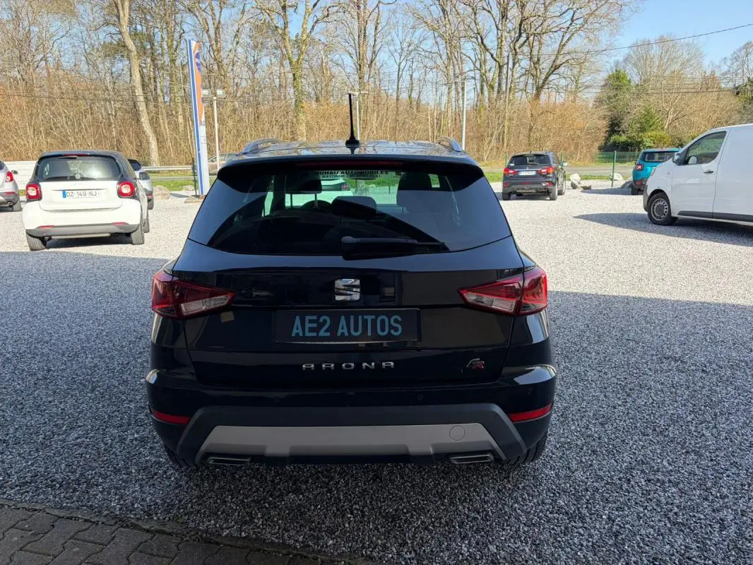 Vue arrière d'un SEAT Arona noir 2020 avec logo FR et double sortie d'échappement sur un parking extérieur.