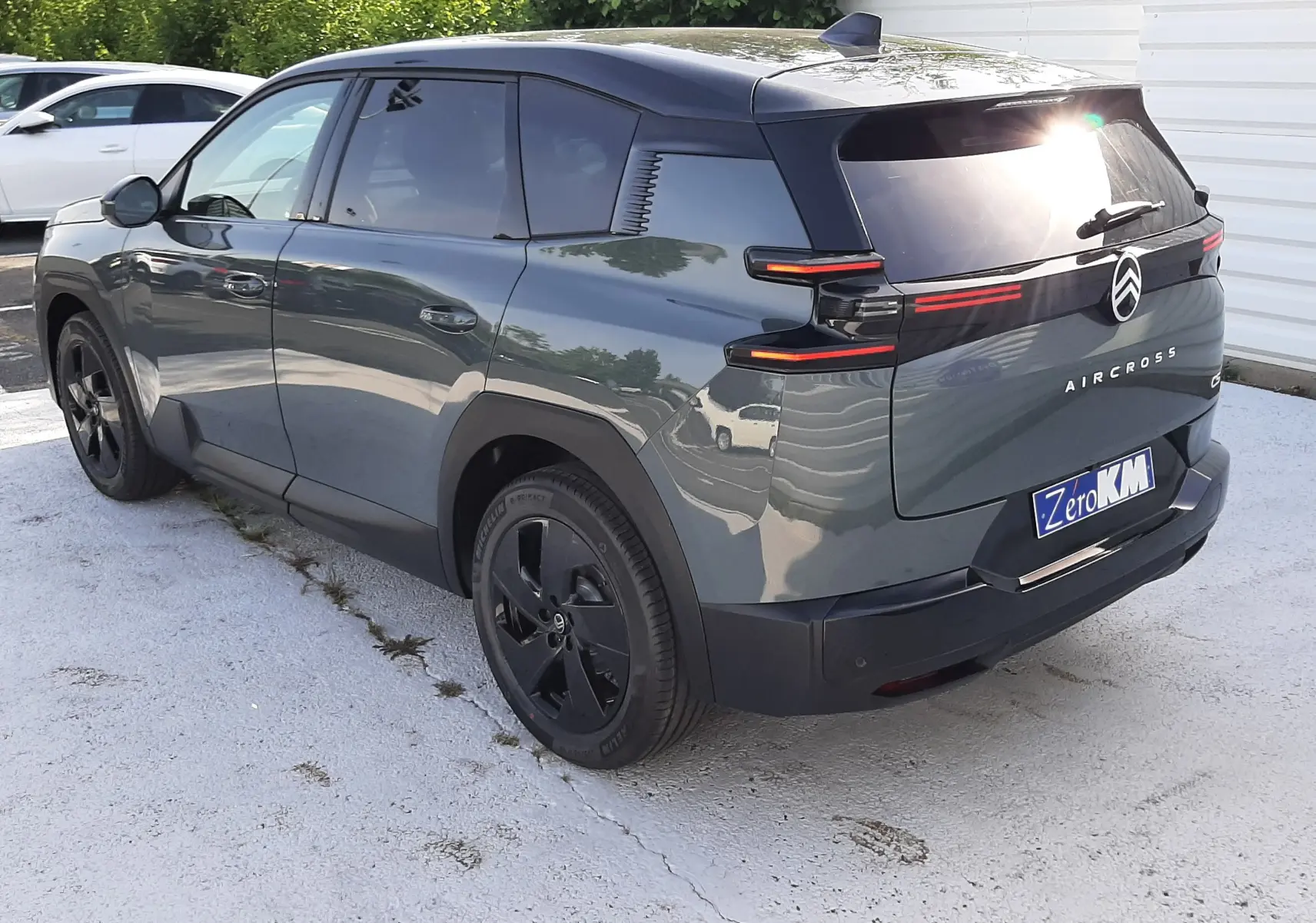 Vue 3/4 arrière gauche d'un Citroën C5 Aircross vert Astoria avec toit noir et feux arrière LED distinctifs.