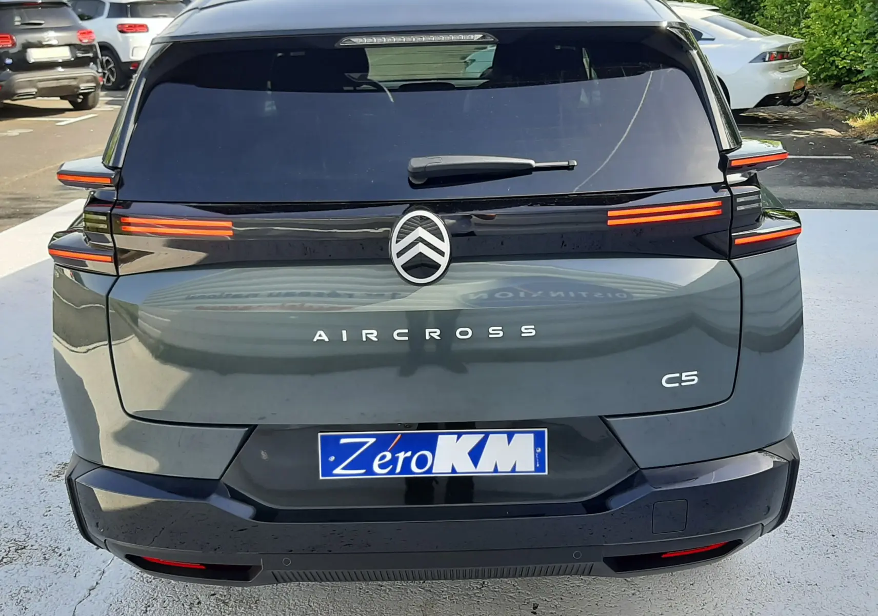 Vue arrière d'un Citroën C5 Aircross vert Astoria avec toit noir, feux arrière LED étirés et hayon électrique visible.