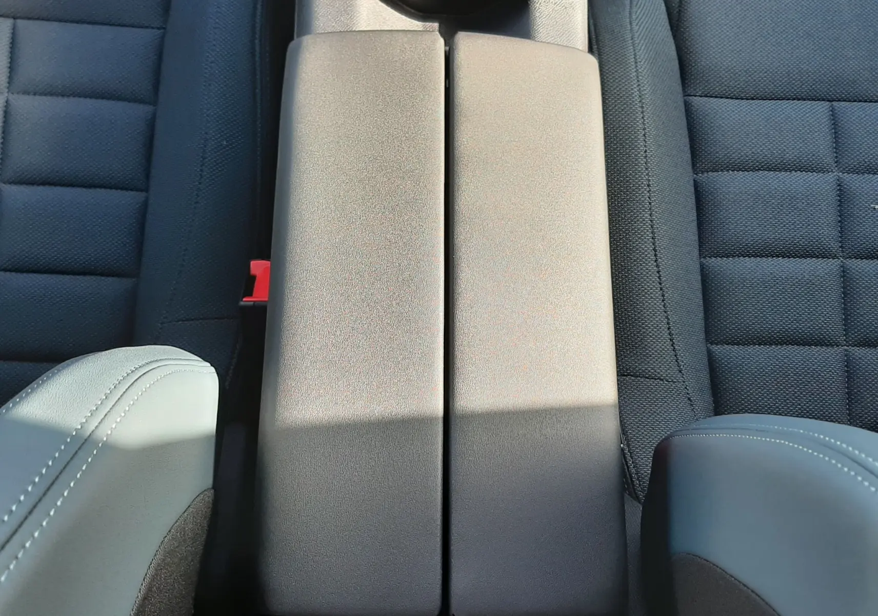 Vue plongeante sur la console centrale grise entre les sièges avant en tissu noir du Citroën C5 Aircross 2026.