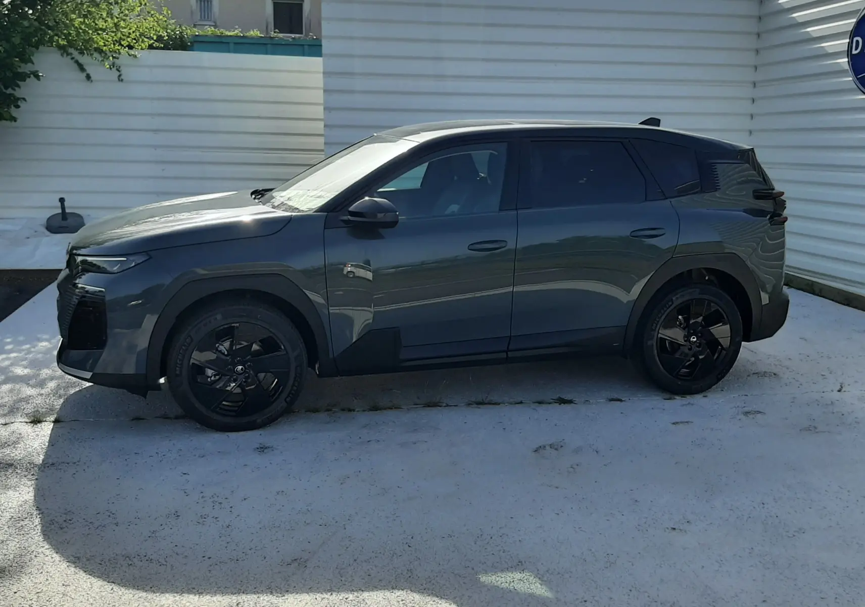 Vue de profil côté gauche du Citroën C5 Aircross hybride 2026 en vert Astoria avec toit noir et jantes noires.