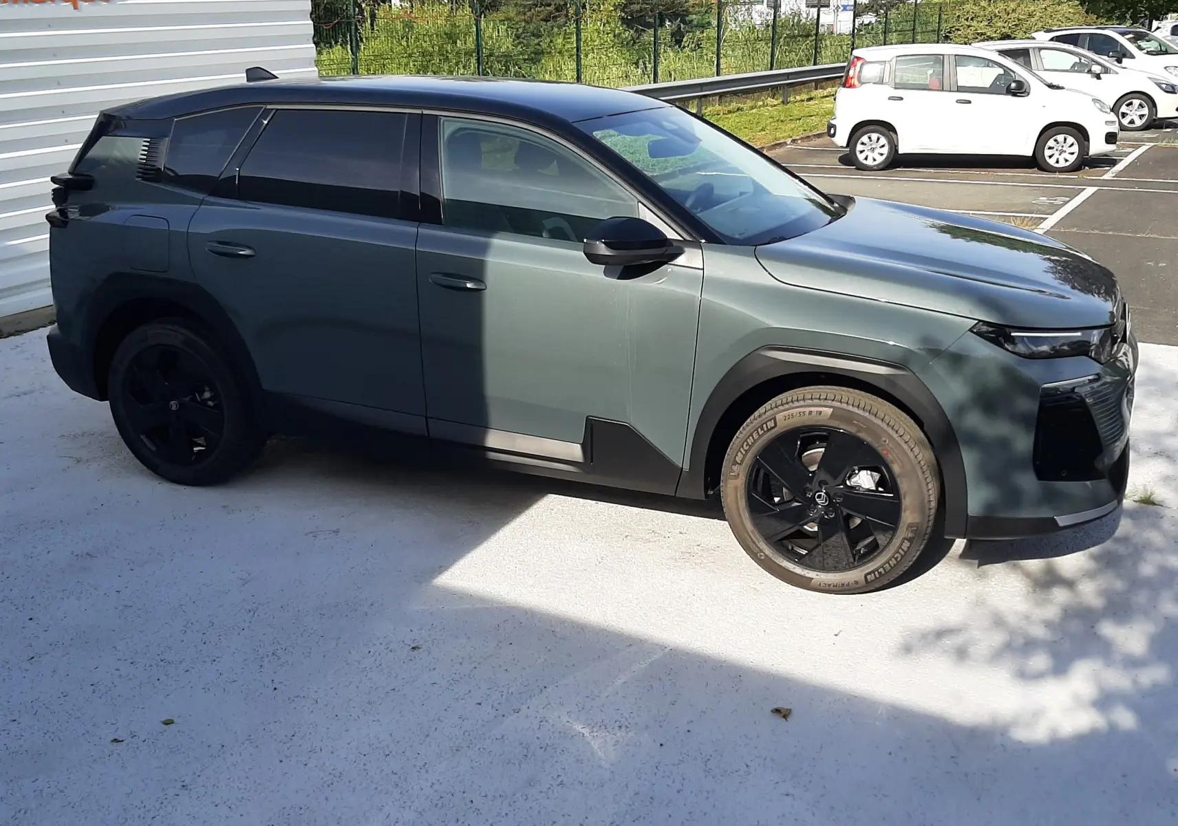 Vue côté gauche d'un Citroën C5 Aircross 2026 vert Astoria avec toit noir et jantes noires, stationné en extérieur.