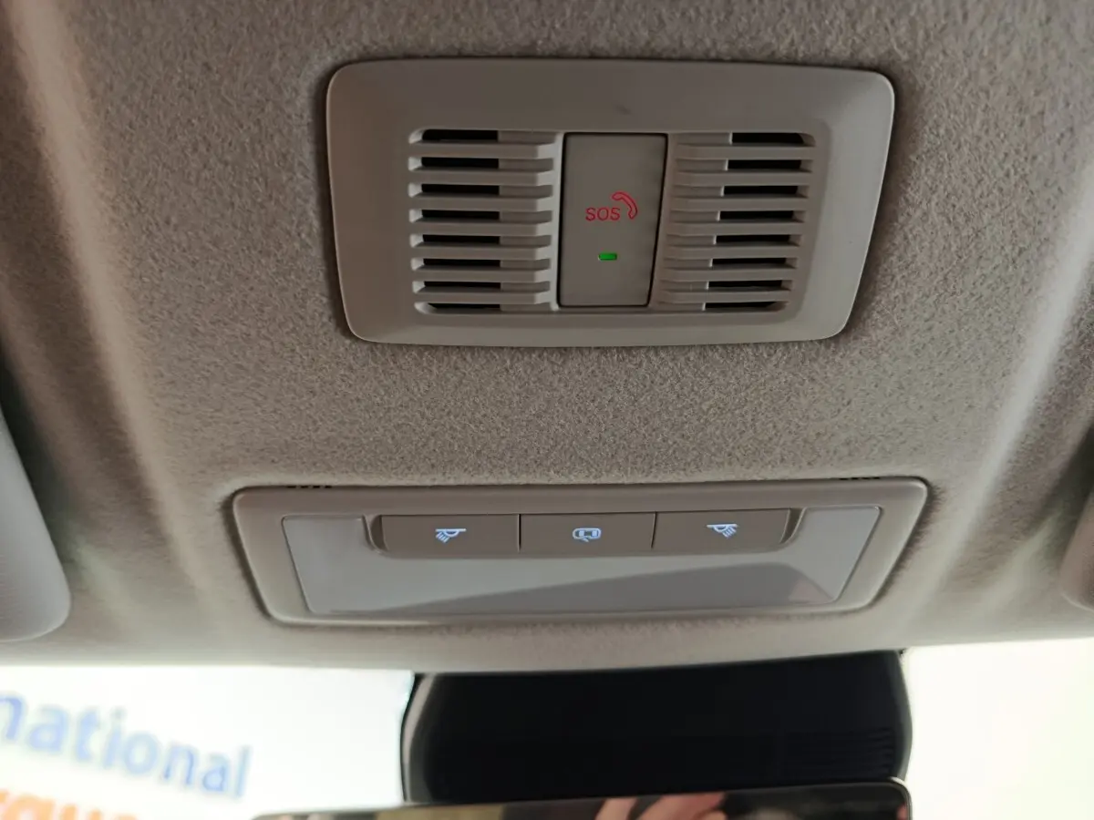 Vue intérieure du plafond beige avec bouton SOS rouge et commandes d'éclairage dans un MG ZS blanc hybride 2026.