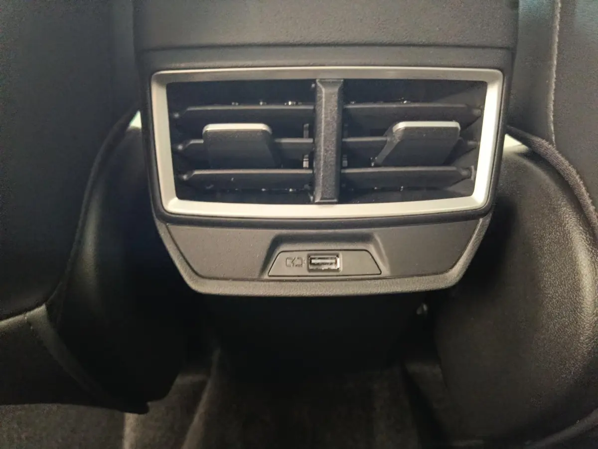 Prise USB et sortie d’air arrière encadrées de plastique noir dans l’habitacle du MG ZS blanc.