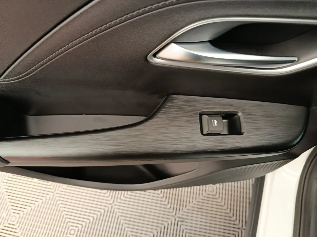 Détail de la porte côté conducteur du MG ZS blanc 2026 avec bouton de verrouillage et finition noire texturée.