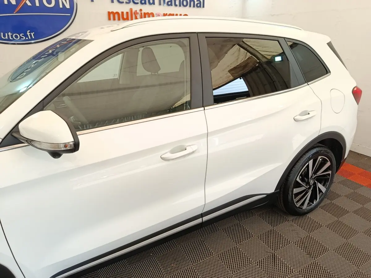 Vue latérale droite du MG ZS blanc avec jantes alliage noires et détails noirs sur les bas de caisse.