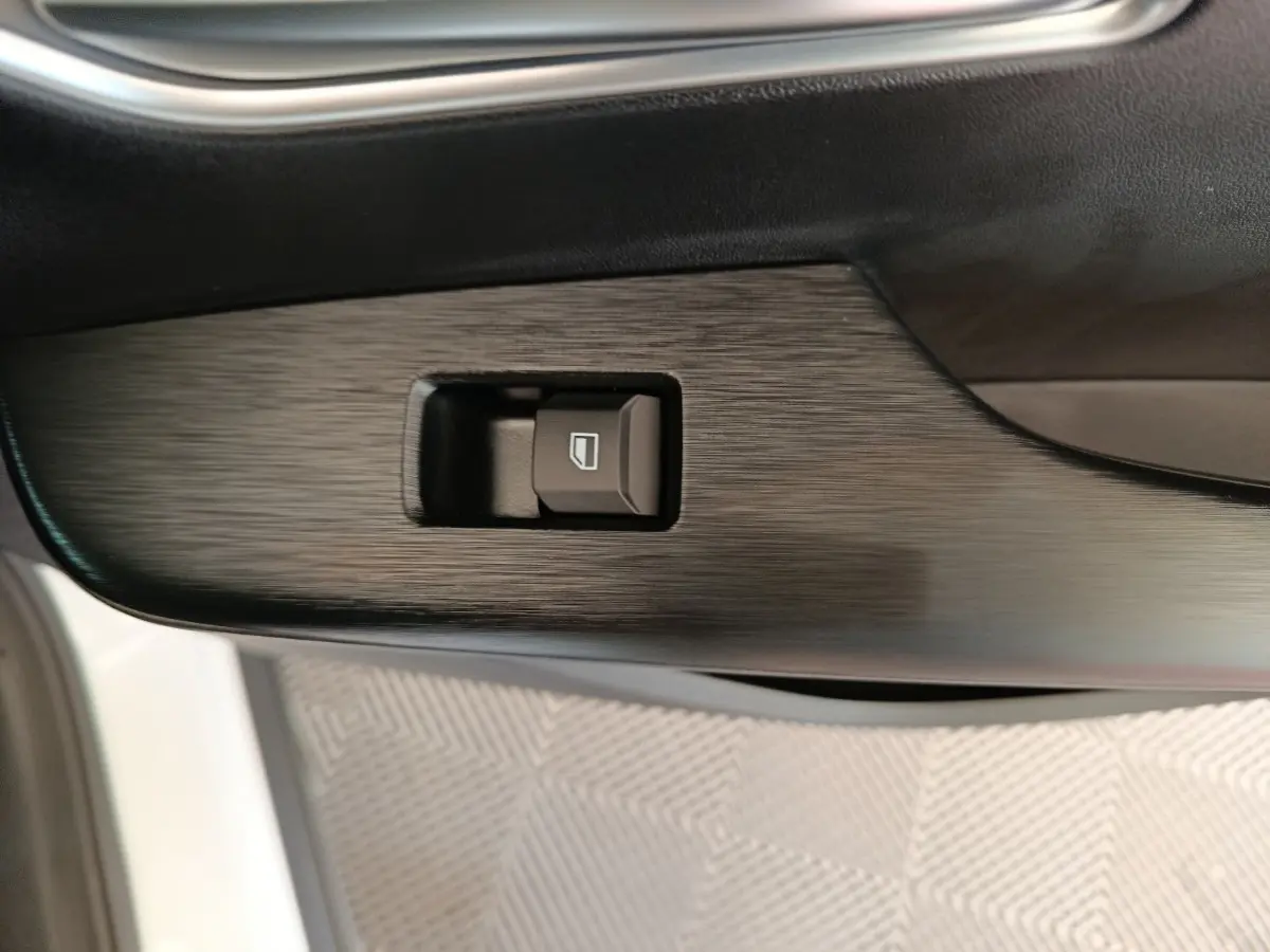 Bouton de commande de lève-vitre sur la porte intérieure côté conducteur d’un MG ZS blanc.
