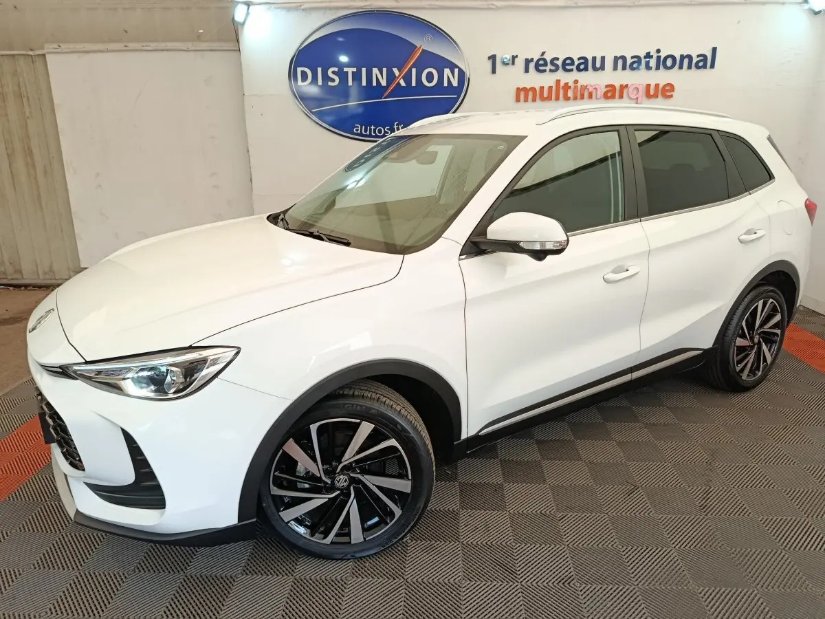 MG ZS blanc en vue 3/4 avant droit, avec jantes alliage noires et toit blanc dans un showroom intérieur.