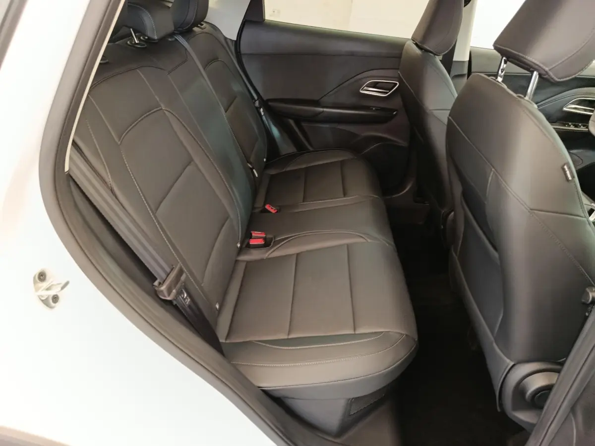 Vue côté gauche sur la banquette arrière en cuir noir du MG ZS blanc, avec accoudoirs centraux visibles.