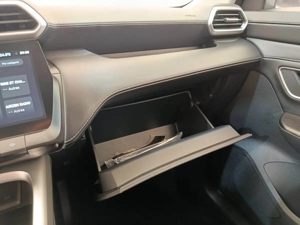 Intérieur MG ZS 1.5L Hybrid+ Luxury vu côté passager, boîte à gants ouverte avec documents visibles.