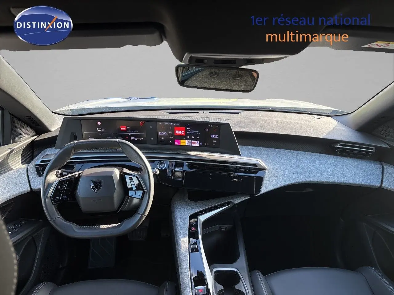 Vue intérieure du tableau de bord et volant du Peugeot 5008 1.2 Hybride 145 Allure avec finition tissu noir et écran digital panoramique.