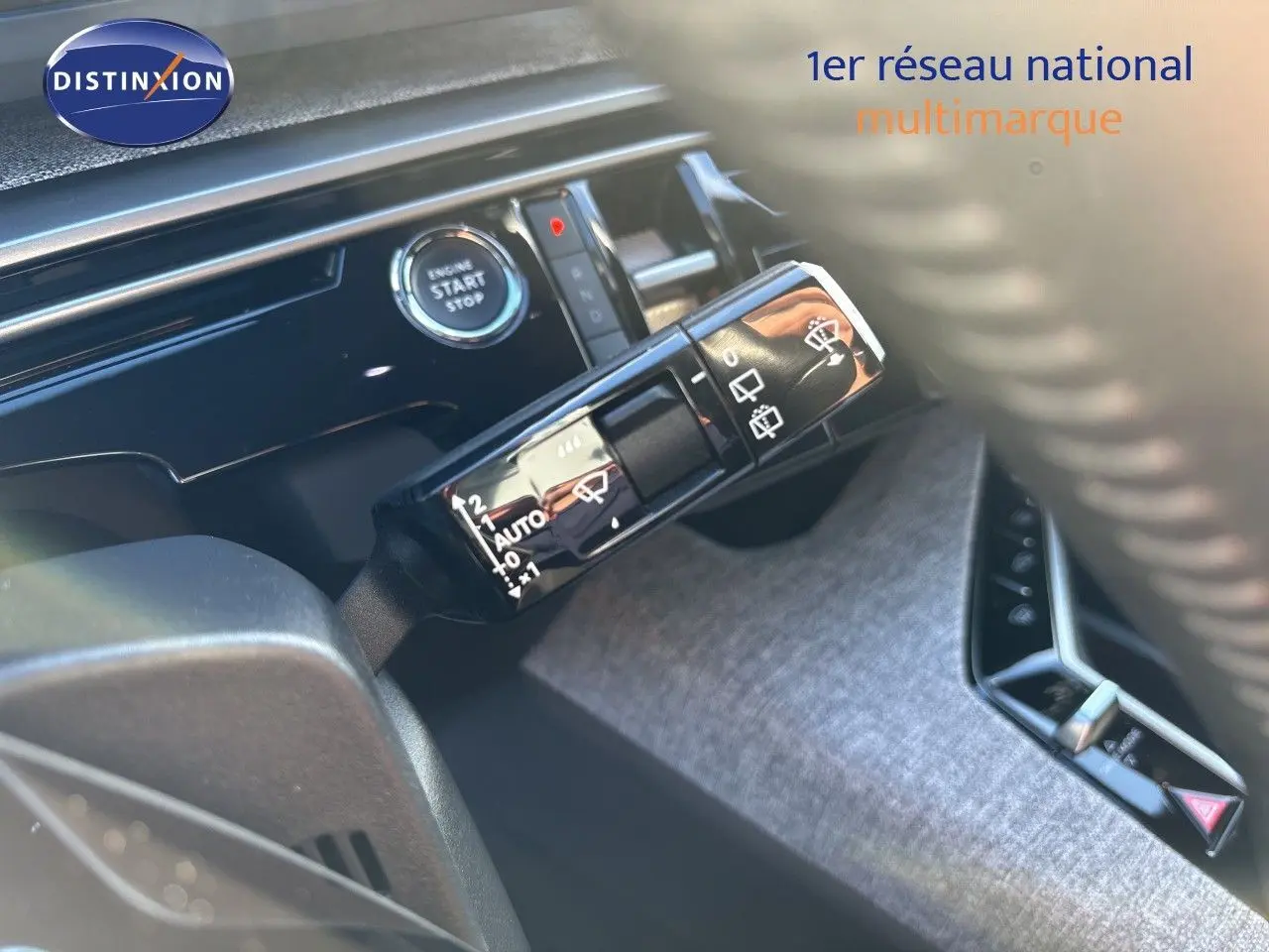 Détail intérieur du Peugeot 5008 2025 montrant la commande d’essuie-glace et le bouton start/stop sur fond de tableau de bord noir.