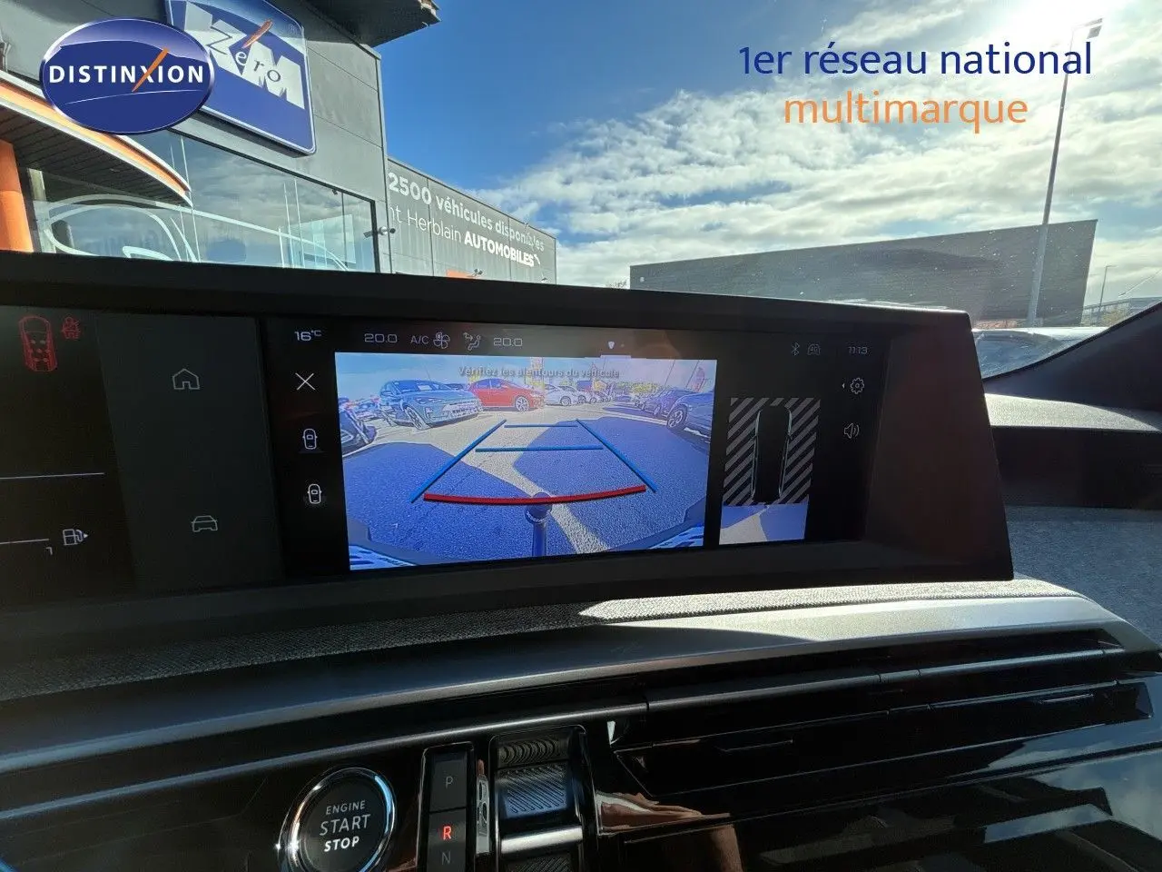 Vue intérieure du tableau de bord du Peugeot 5008 blanc Okenite 2025, avec écran affichant la caméra de recul.