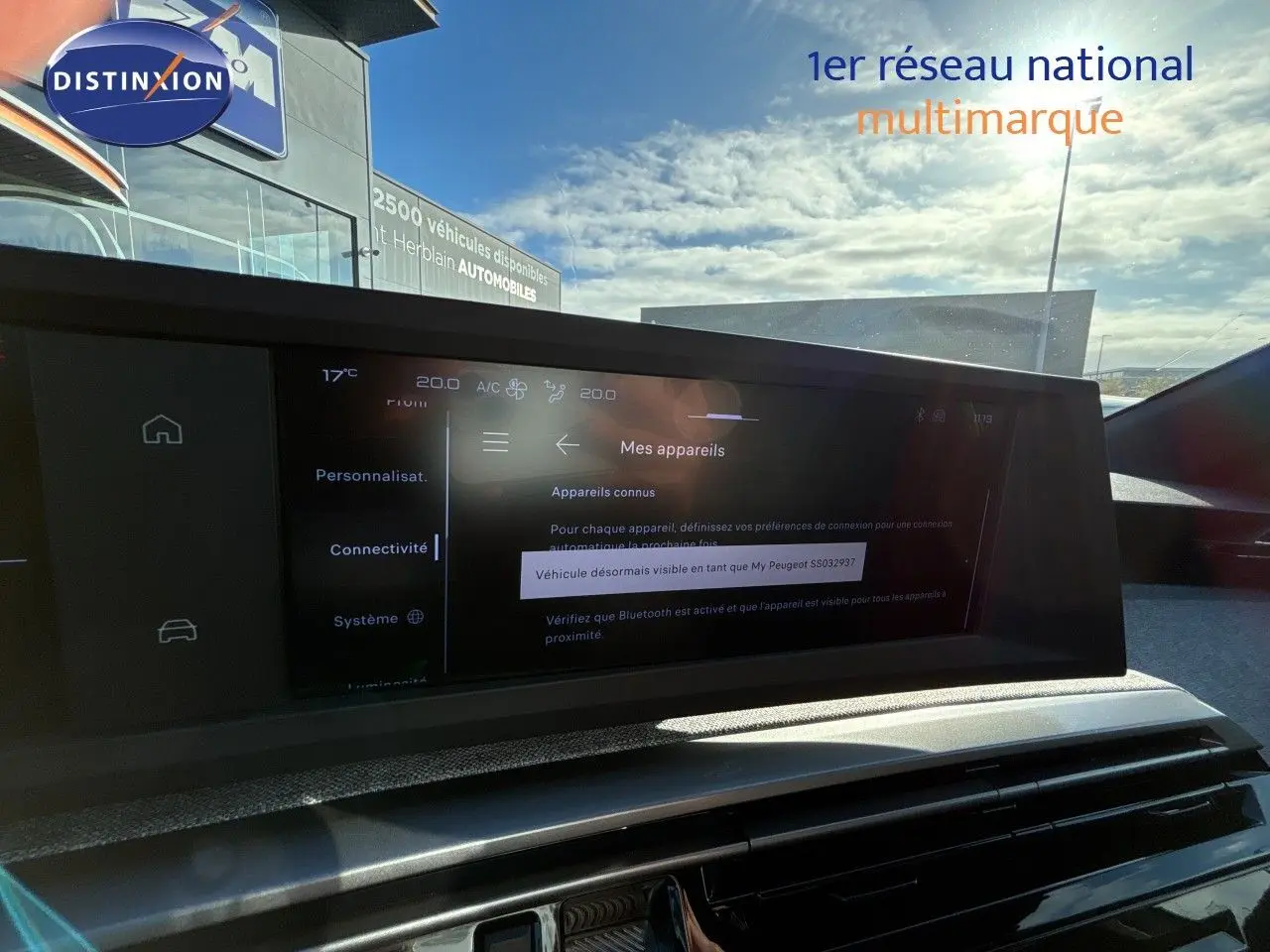 Vue intérieure du tableau de bord du Peugeot 5008 blanc Okenite, écran tactile affichant les paramètres de connectivité.