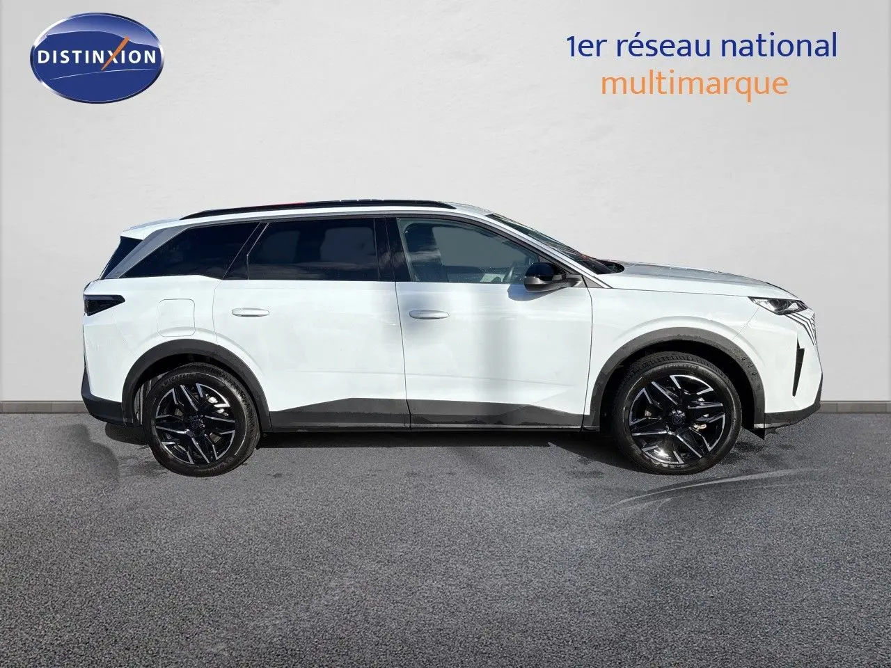 Profil droit d'un Peugeot 5008 blanc Okenite 2025, version hybride, avec jantes noires et toit panoramique.