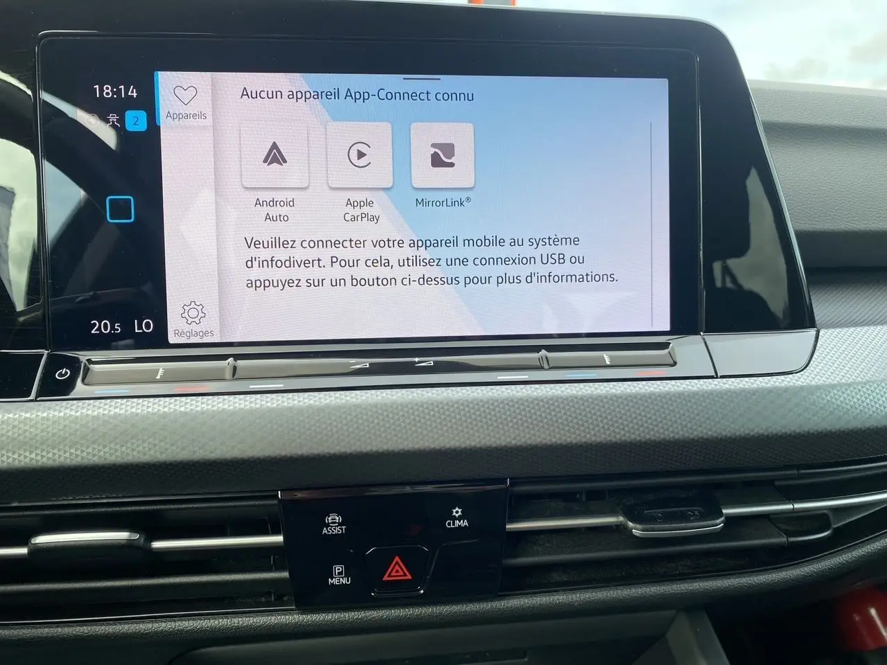 Écran tactile central du tableau de bord d'une Volkswagen Golf VIII noire, affichant les options de connectivité mobile.