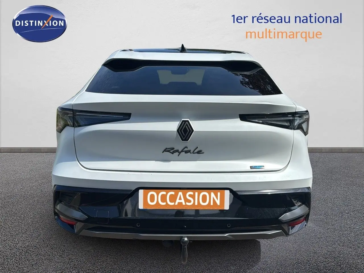 Vue arrière d'une Renault Rafale blanche satin avec toit noir et attelage visible sur fond neutre.