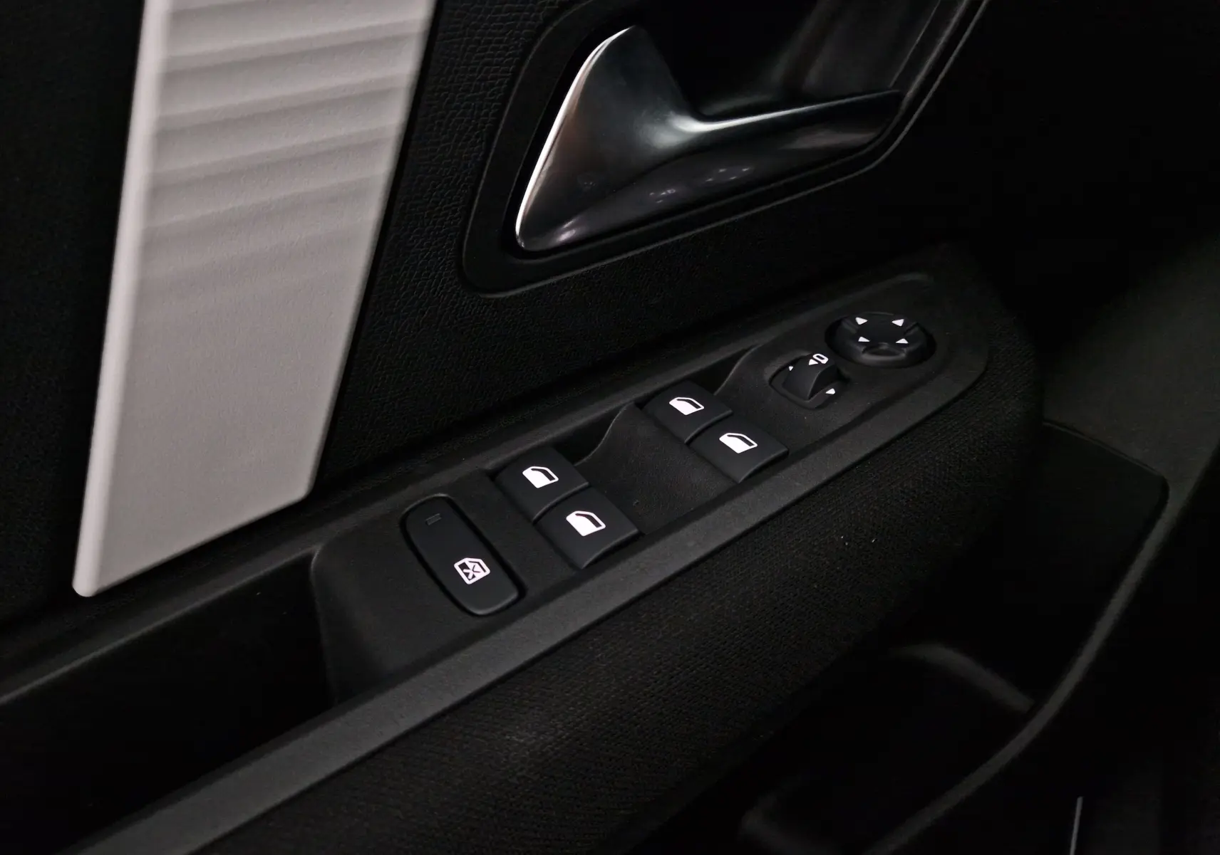 Gros plan sur la commande des vitres et rétroviseurs côté conducteur d'une Citroën C4 2025 gris mercury/noir.
